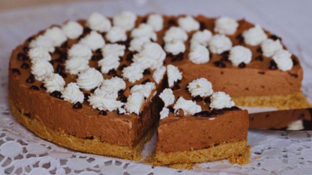 Cheesecake de chocolate com chantilly, base de bolacha e acréscimo de cream cheese e raspas de laranja no recheio