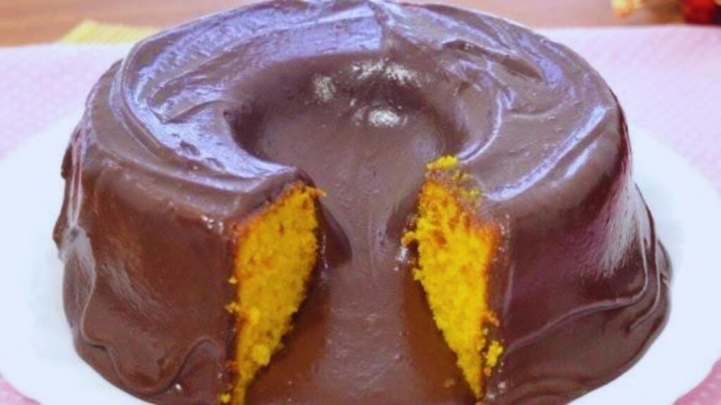 Bolo de cenoura com calda de chocolate que, se cortar morno, tem efeito vulcão